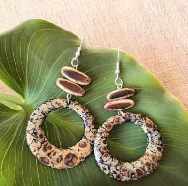 Boucles d'oreilles en formes circulaires avec motif léopard et perles marron.